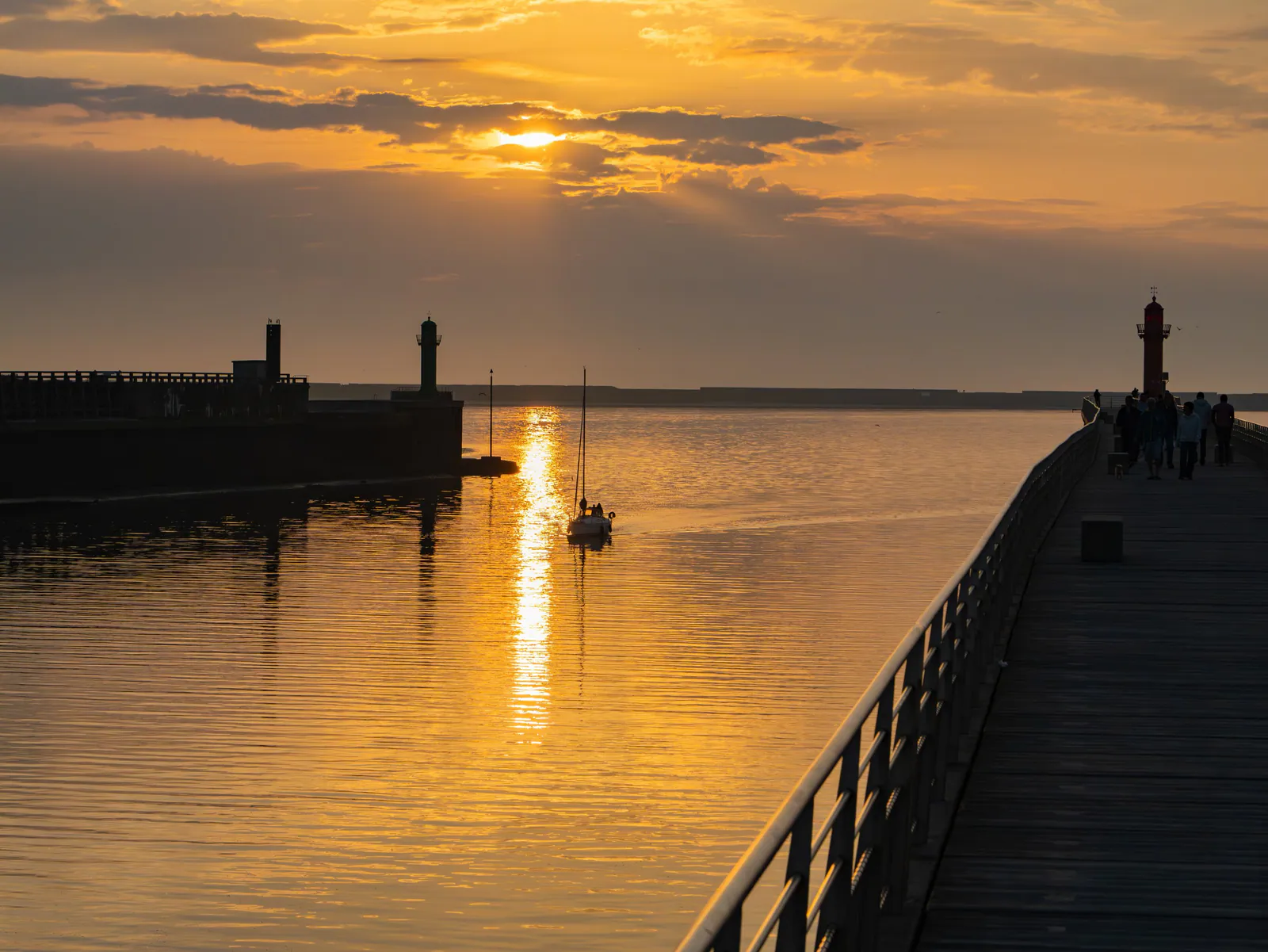 Silhouette des phares et des digues du port de Boulogne-sur-Mer au coucher de soleil doré